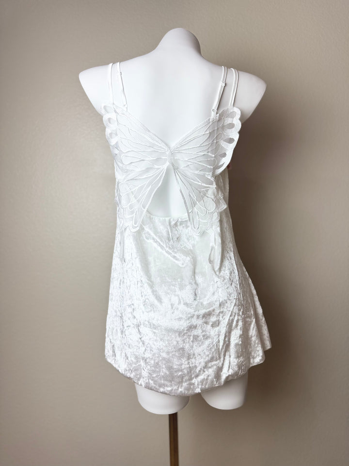 back of a white Velvet Butterfly Back Slip dress on a mannequin against a beige background