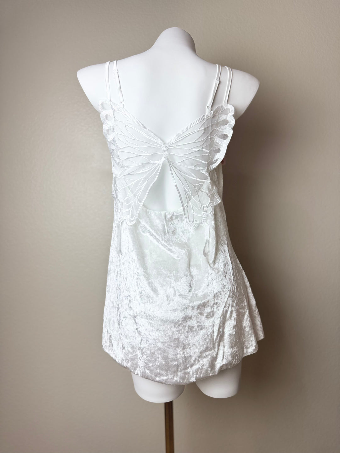 back of a white Velvet Butterfly Back Slip dress on a mannequin against a beige background