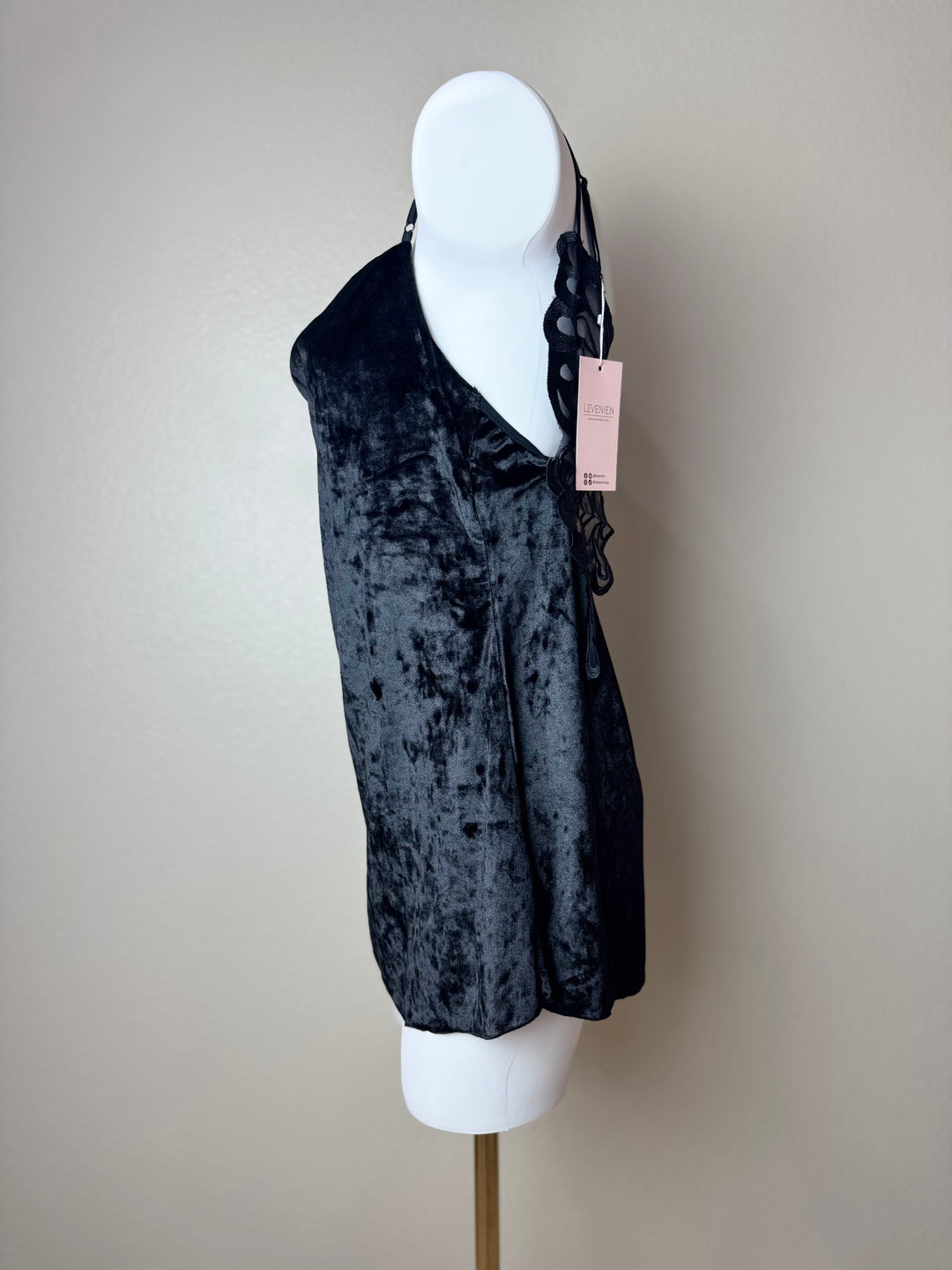side of a black Velvet Butterfly Back Slip dress on a mannequin against a beige background